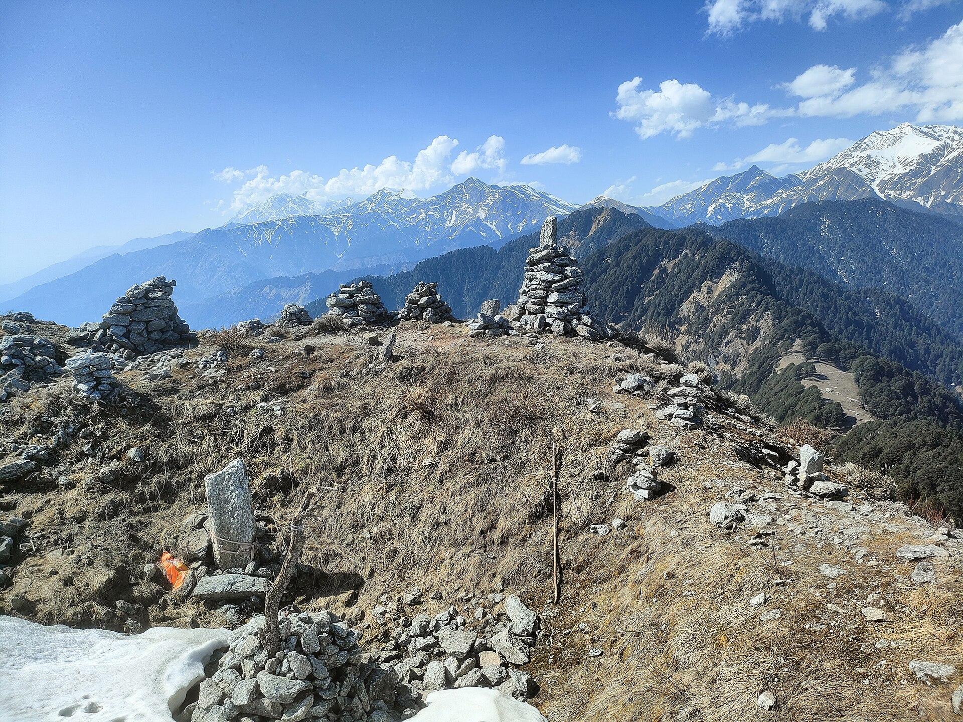Stone cairns on a ridgetop above Bir, snow peaks behind