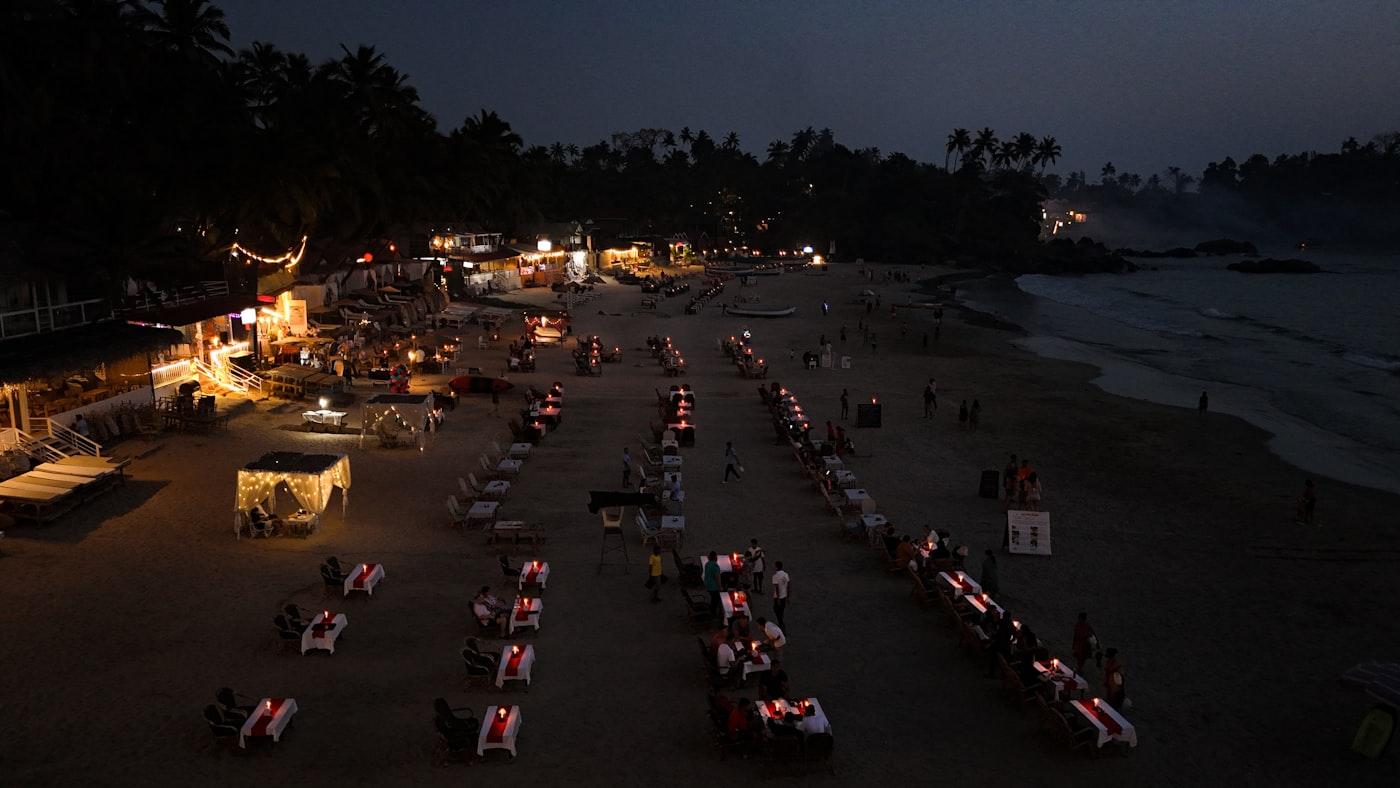 Lantern-lit tables on a beach after dark