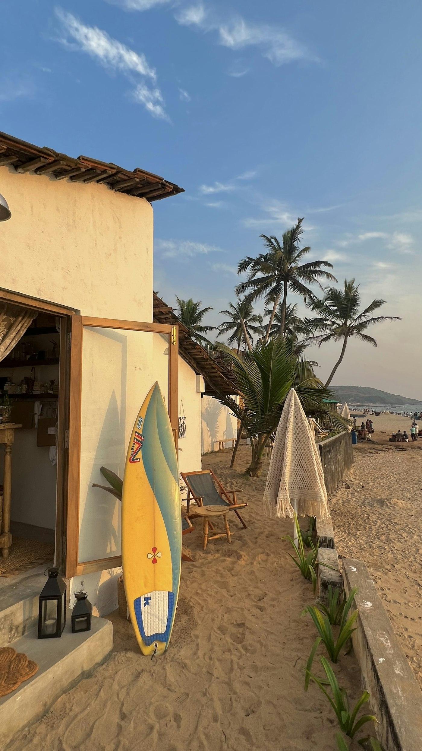 A surfboard propped against a beach cafe wall