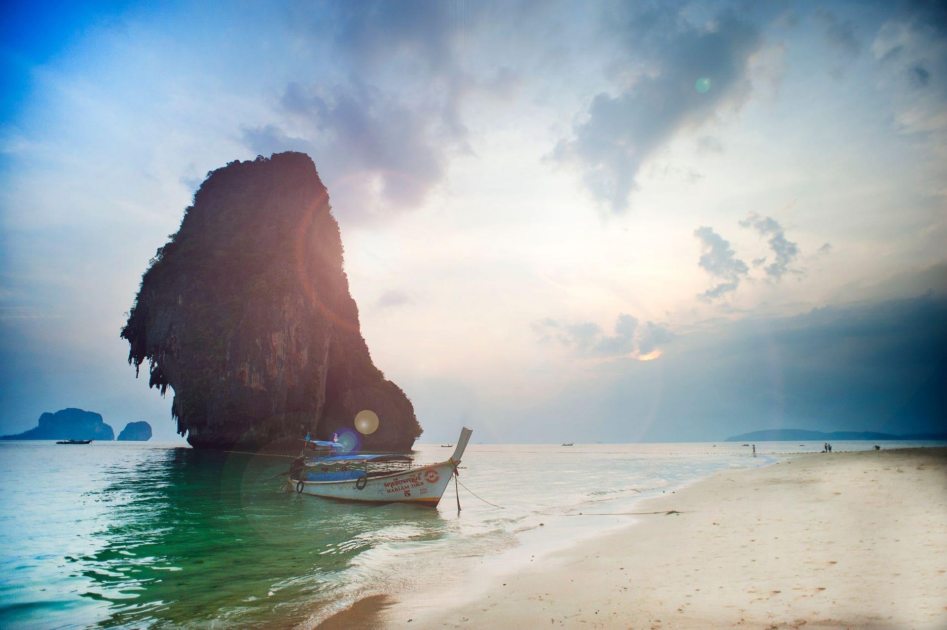 A Krabi beach at low sun with a moored longtail